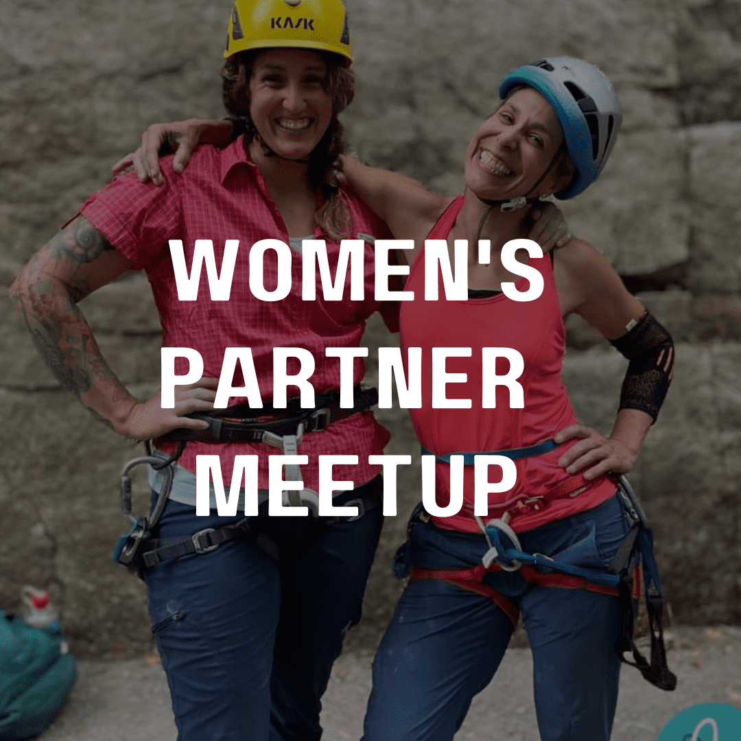 Two women posing for a picture in front of a wall.