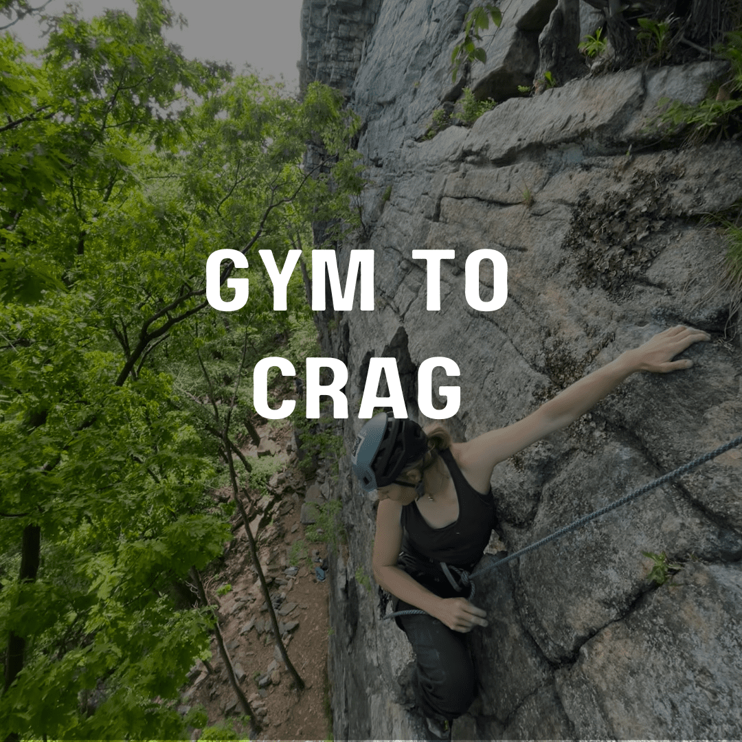 A woman climbing up the side of a rock wall.