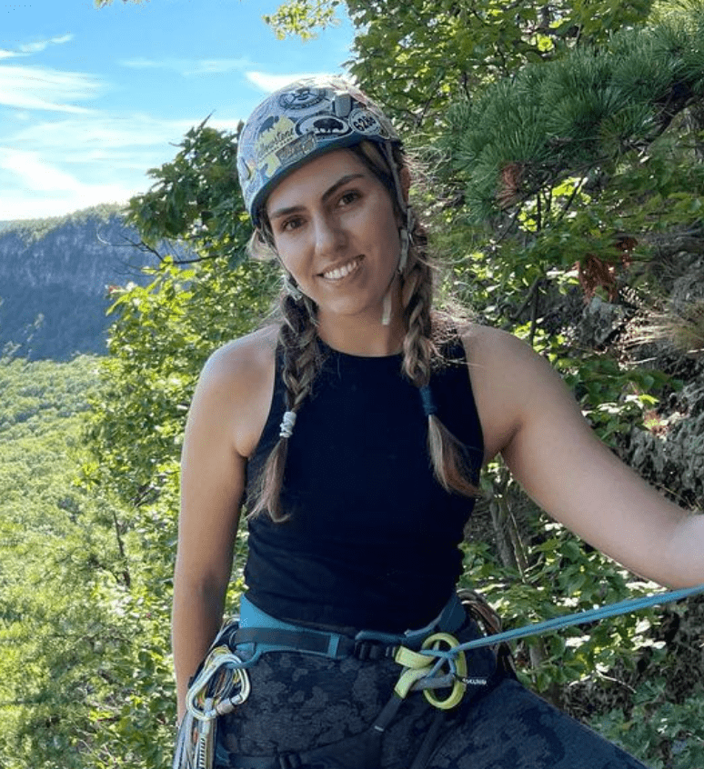 A woman in black shirt holding onto rope.